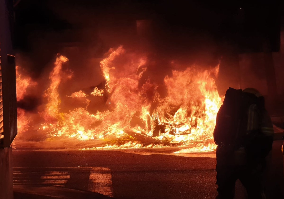 Un bombero de Benalmádena delante de las llamas que provocaron los tres vehículos ardiendo.