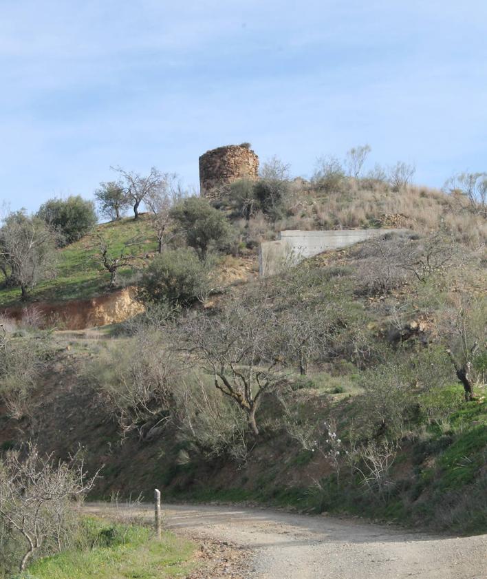 Imagen secundaria 2 - La atalaya se encuentra sobre un cerro situado en propiedad privada. Abajo, vista panorámica desde la torre de los Verdiales. La ruta de senderismo que une a Puerto de la Torre con Ciudad Jardín pasa a los pies de la atalaya.