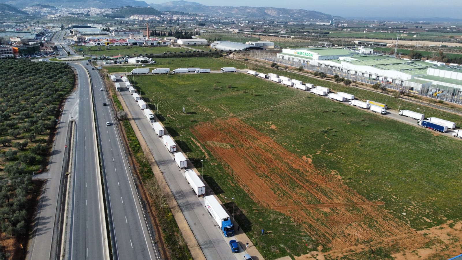 Protestas en Antequera: la entrada de camiones a las principales plataformas logísticas está totalmente paralizada. En esta imagen aérea se aprecia la cola de camiones, que no pueden avanzar por el bloqueo realizado por los tractores.