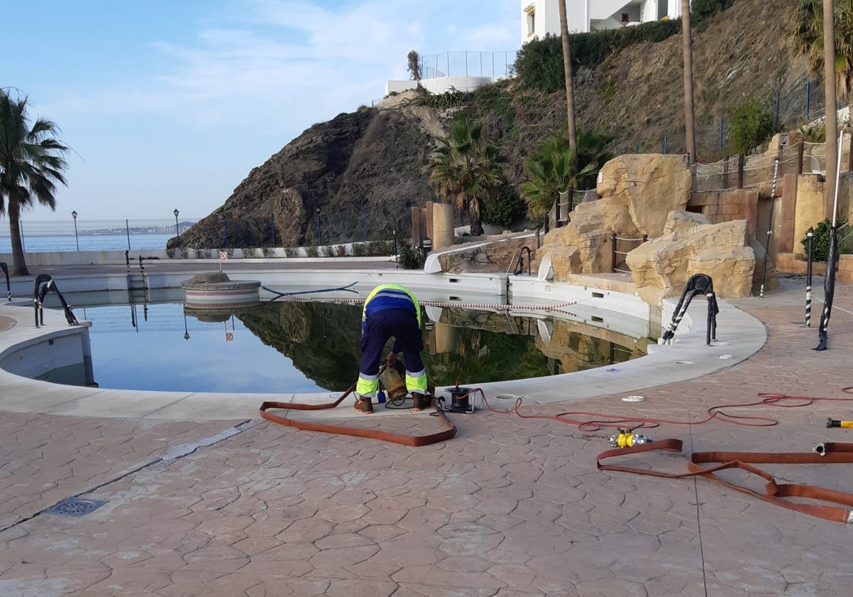 Operarios municipales recogen el agua de una piscina, donada por un hotel de Benalmádena.