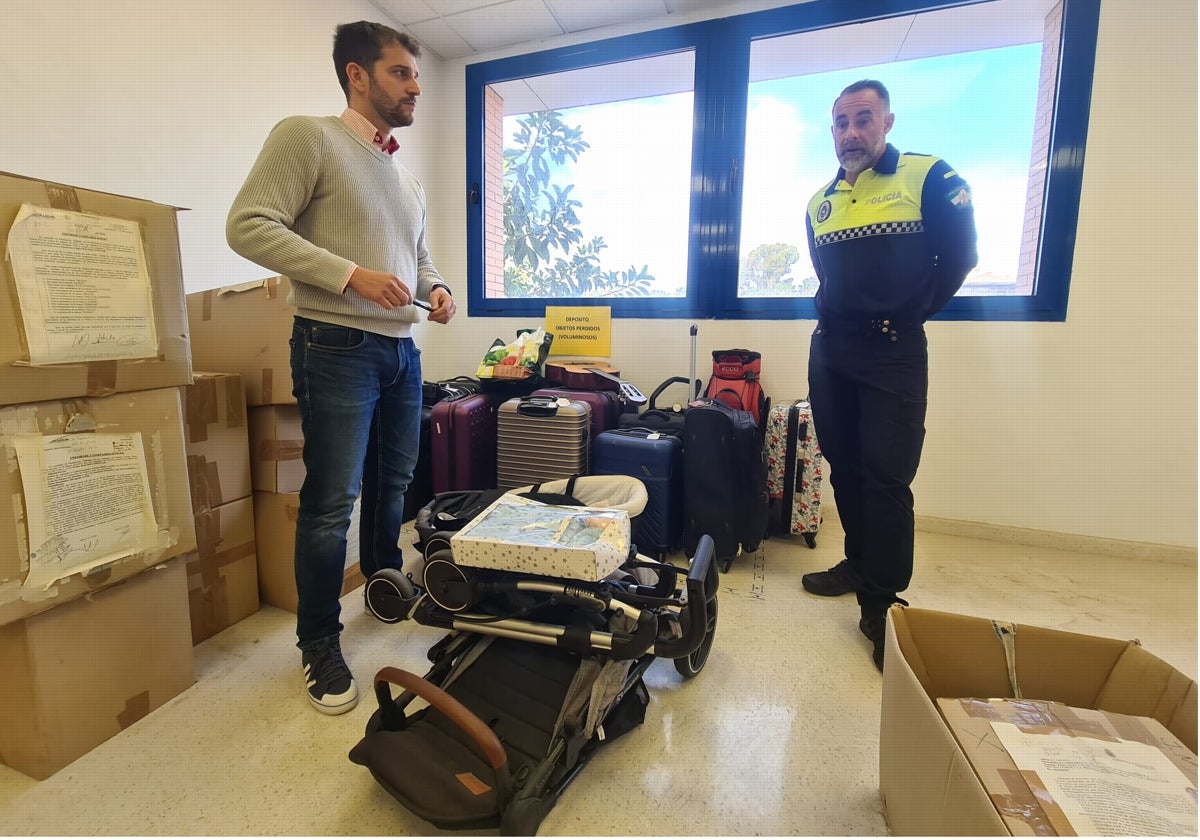 El concejal de Seguridad Ciudadana y el policía responsable de la Oficina de Objetos Perdidos junto a parte del material almacenado.