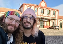 Rafa y Fer con la estación de trenes de fondo, su actual hogar.