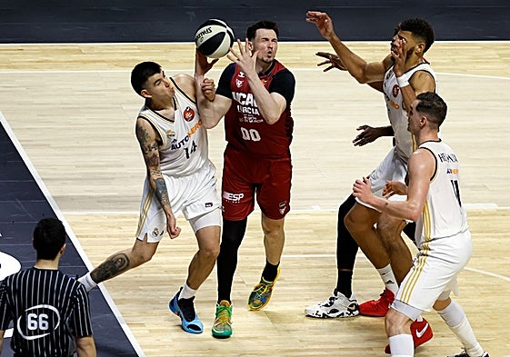Kurucs pelea por un rebote rodeado de jugadores del Madrid.