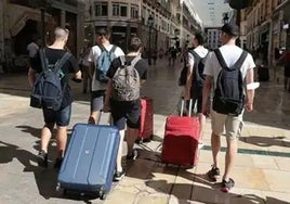 Turistas, en la calle Larios de la capital.