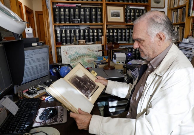 Juan Antonio Fernández Rivero observa la fotografía más antigua de Málaga, que se trata de una imagen tomada en la Alameda en 1851.