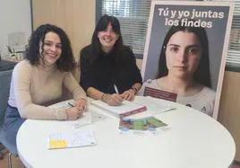 Luisa Bueno (dcha), trabajadora social de la ONG 'Crecer con Futuro', con Sara Gómez y el cartel de la campaña 'Tú y yo juntos los findes'
