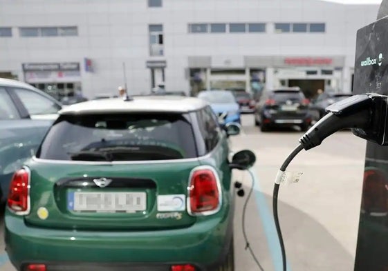 Un turismo eléctrico enchufado a un punto de recarga en un concesionario.