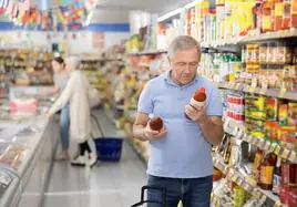 Un usuario lee el contenido de la etiqueta de unos productos del supermercado.