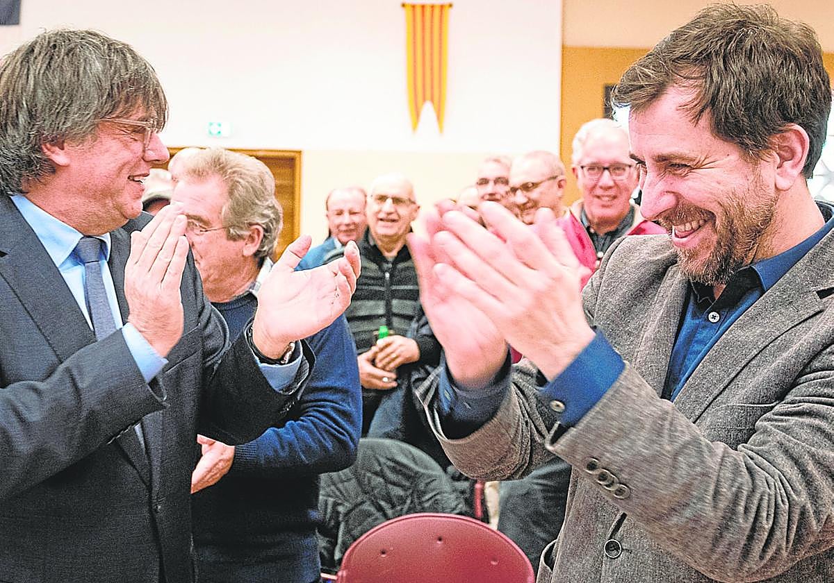 Puigdemont, sonriente tras la aprobación de la ley en la Comisión de Justicia, junto a Toni Comin.
