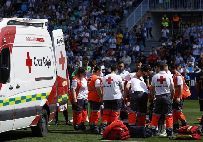 La ambulancia, dentro del terrenode juego, y los efectivos de Cruz Roja.