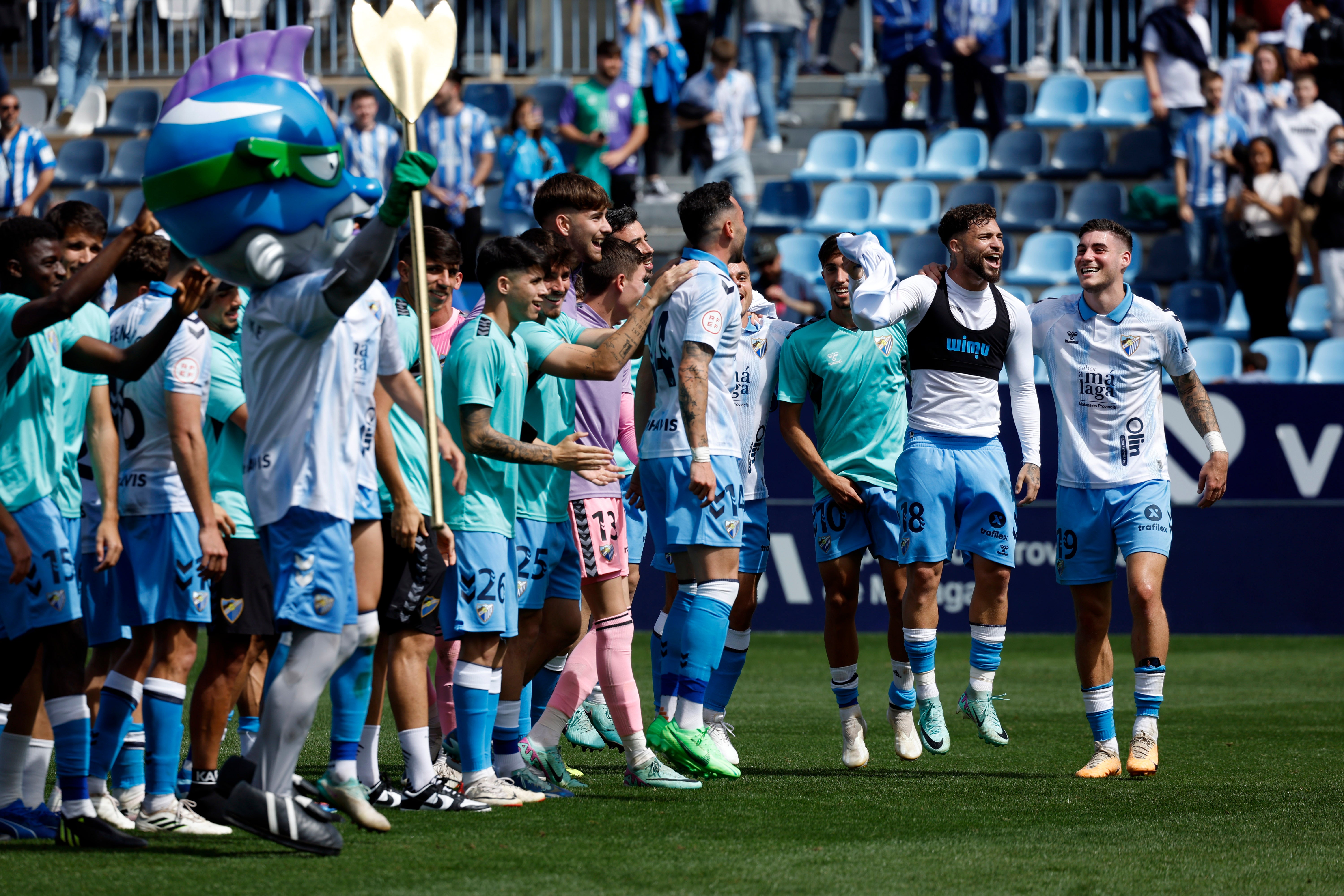 Los jugadores del Málaga saltan celebrando la victoria de cara a los aficionados.