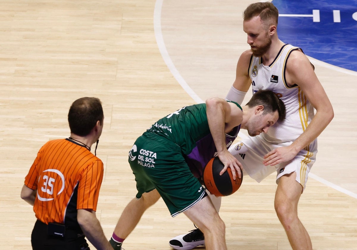 Pérez Pizarro observa una acción entre Kalinoski y Musa en el Unicaja-Real Madrid.