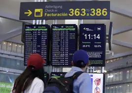 Turistas buscan información de su vuelo en uno de los paneles del aeropuerto de Málaga.