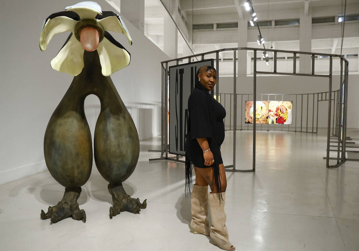 Theresa Chromati, junto a la escultura de la flor escroto que da entrada a la exposición.