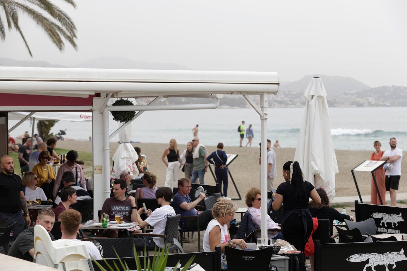 El tiempo casi veraniego llena playas, terrazas y chiringuitos a pesar de la calima en Málaga