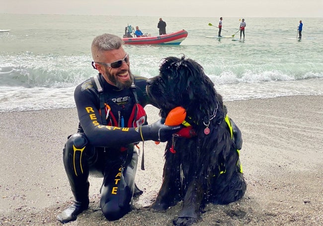 Miguel Sánchez, junto a su terranova Queen, de seis años, este domingo en la playa de Torre del Mar.