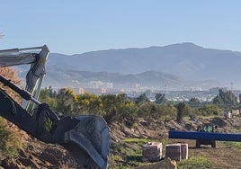 Maquinaria trabaja en el Camino del Puente del Rey, en suelo alhaurino, con la vista de Málaga al fondo.