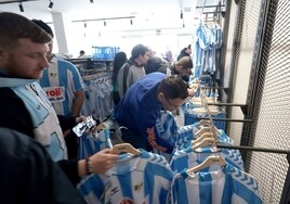 Aficionados compran la nueva camiseta del Málaga en la tienda oficial.