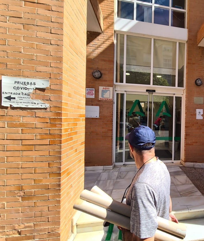 Imagen secundaria 2 - Arriba y en el centro, recreaciones virtuales del exterior e interior del futuro centro de salud. Sobre estas líneas, un vecino pasa por delante del actual centro de salud, en la Avenida del Mediterráneo.