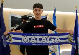 El joven futbolista del Málaga, Aarón Ochoa, posa con una bufanda del Málaga en las oficinas de La Rosaleda tras firmar su ampliación de contrato.