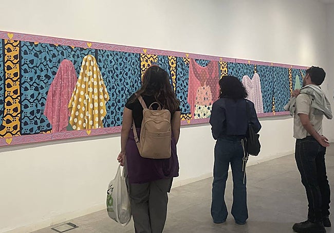 Varias personas observan una las piezas que forman parte de la exposición.