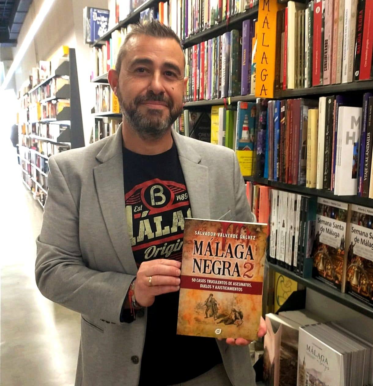 El autor, con su libro 'Málaga Negra 2' en el interior de la Librería Luces.