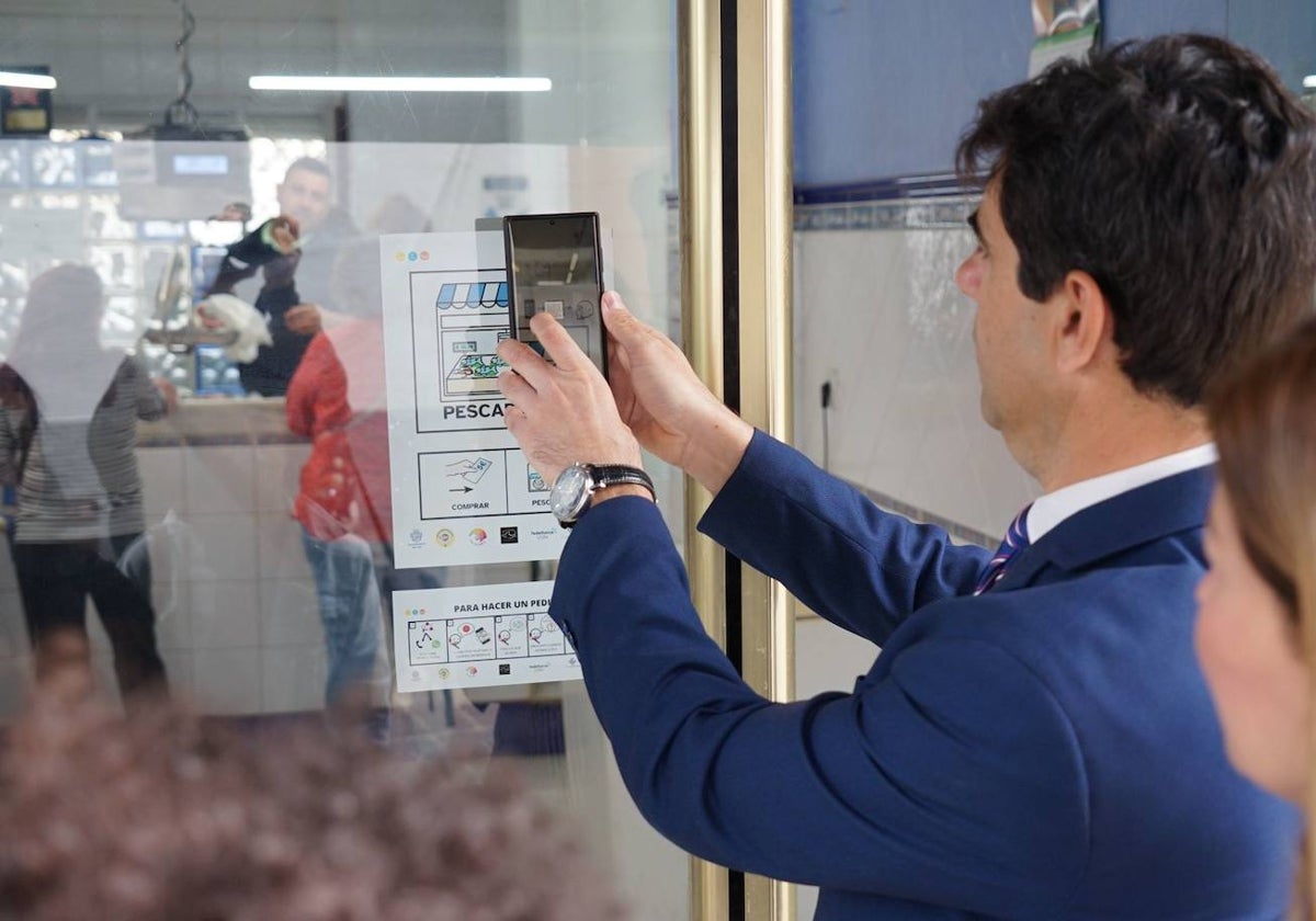 El alcalde de Coín, Francisco Santos, prueba los pictogramas de una pescadería.