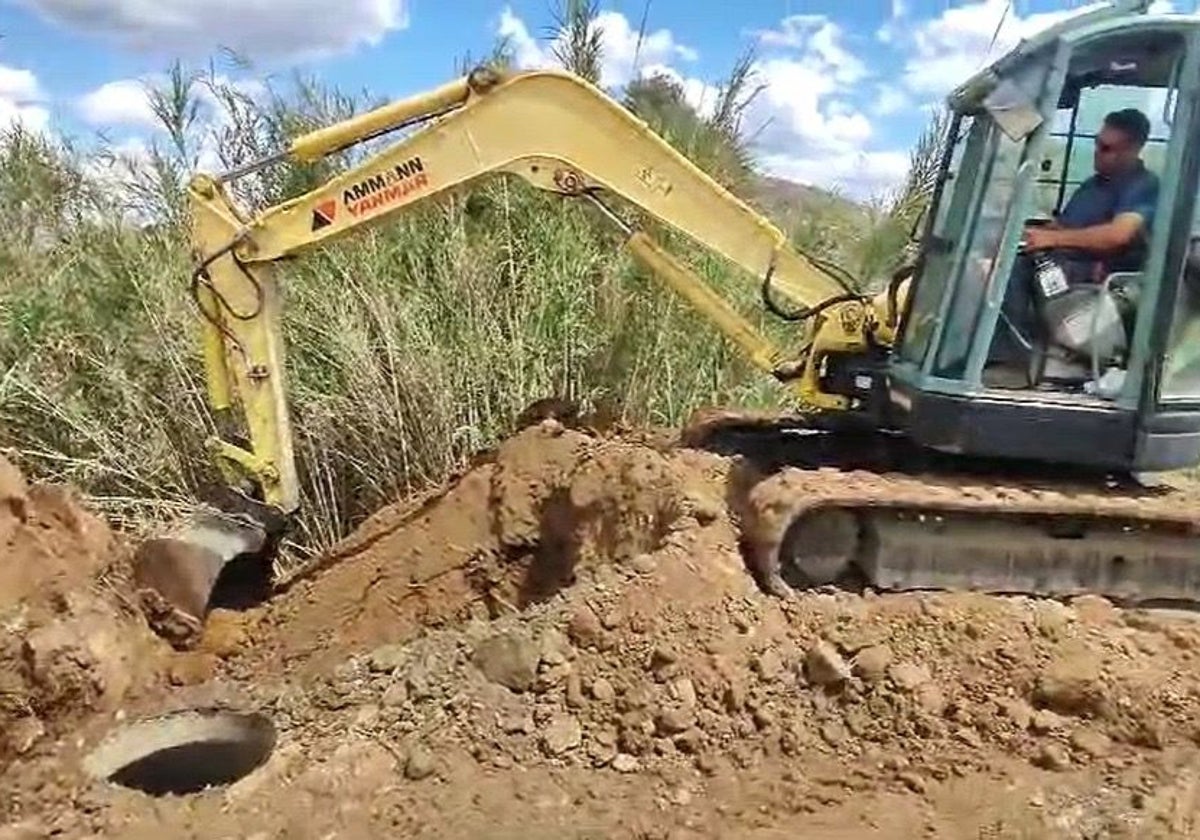 Una máquina excavadora para descubrir la avería de la gran tubería de Cártama.