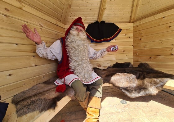 Papá Noel en una cabaña de madera instalada en la entrada de la caseta de Finlandia en la Feria de los Países.