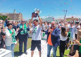 Javi Amaya alza el trofeo de campeón del grupo 9 de Tercera RFEF, que implica el ascenso, delante de las autoridades.