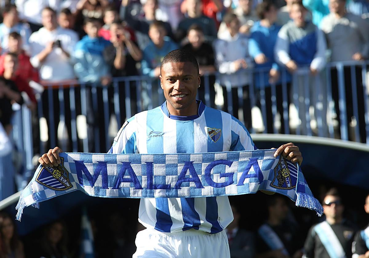 El jugador brasileño Julio Baptista posa en el césped de La Rosaleda con una bandera y una bufanda, ante 3.500 espectadores, en su presentación oficial como nuevo fichaje del Málaga en 2011.