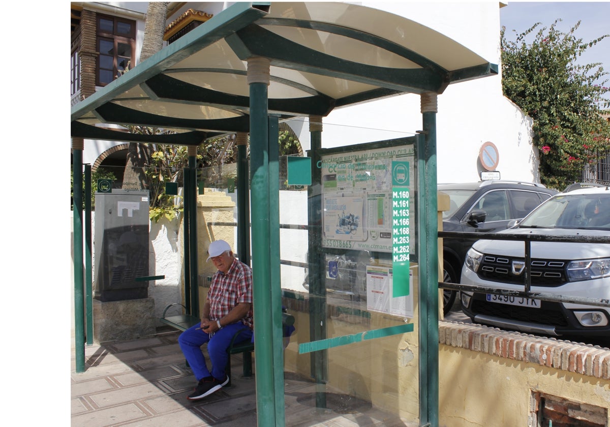 Un usuario espera para coger el autobús en una de las paradas de la Cala del Moral.