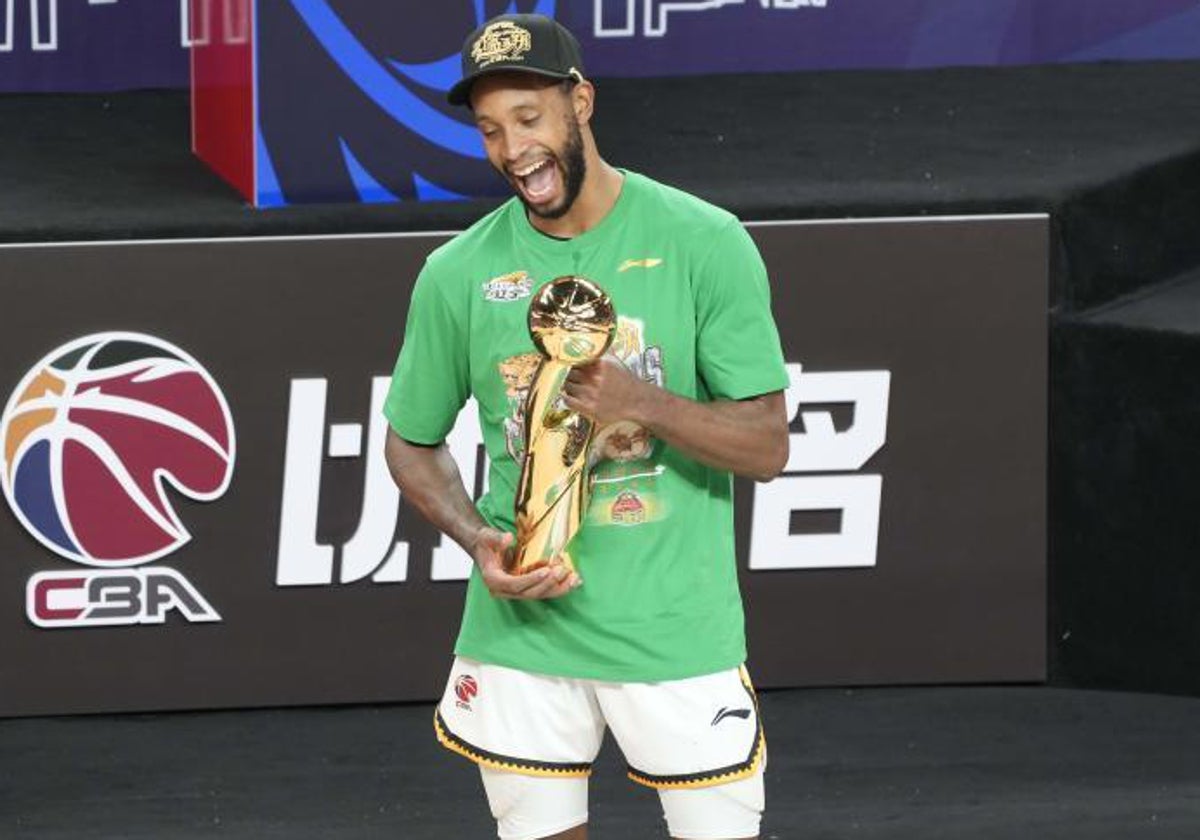 Kyle Fogg posa sonriente con el trofeo de MVP de la CBA china.