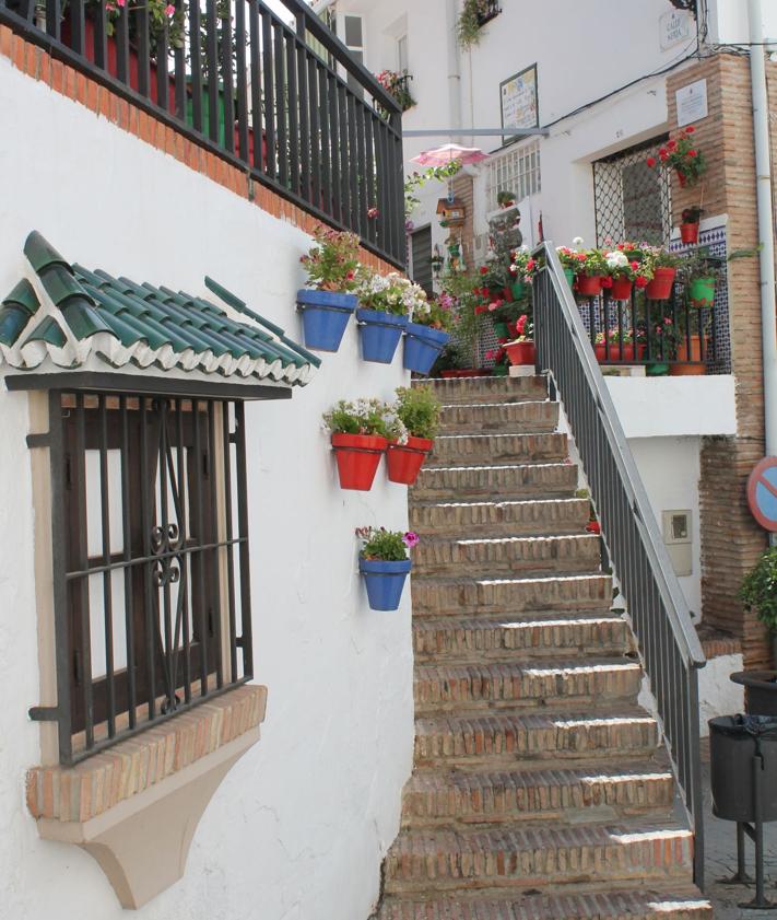 Imagen secundaria 2 - Hay varios faros en miniatura en la parte central de la calle. Abajo, placa que homenajea a Nieves Cortés, la vecina que ha hecho posible que la calle luzca así.