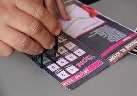 Una persona utilizando el pasaporte de sellos para votar las tapas de Cártama.