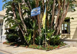 La bandera del Málaga CF ondea en la fachada principal del Ayuntamiento de Málaga.