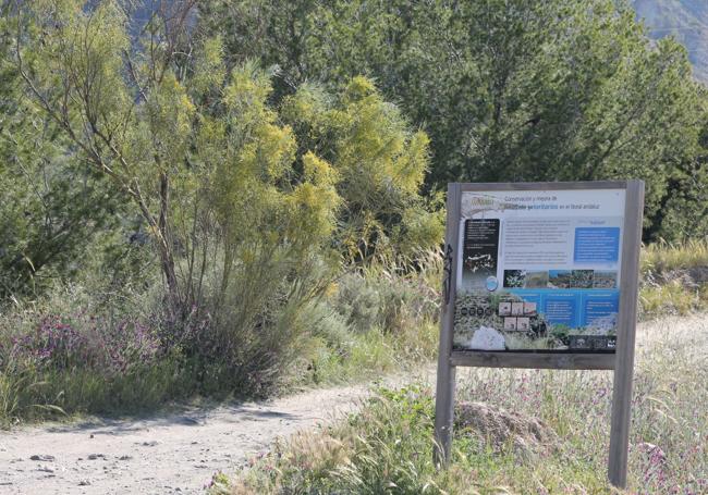 El carril de tierra inicial está junto a un cartel del paraje natural.