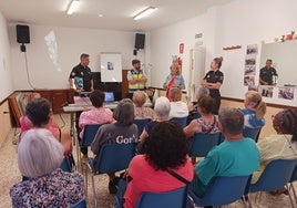 Los agentes y los mayores, durante la charla ofrecida por la Policía Nacional.