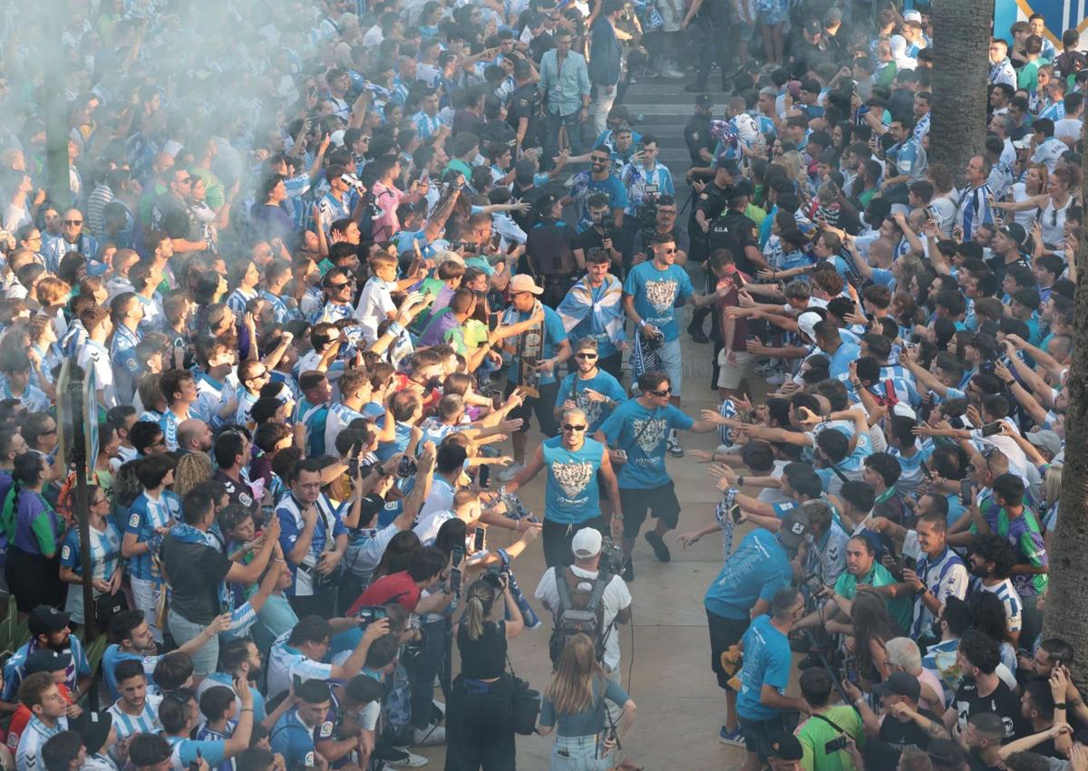 Imagen secundaria 1 - Larrubia hizo de 'speaker' presentando a todo el equipo en el Ayuntamiento. Los jugadores entran al Ayuntamiento mientras chocan las manos de los aficionados. Las autoridades posan con la plantilla y la directiva del Málaga en el Ayuntamiento