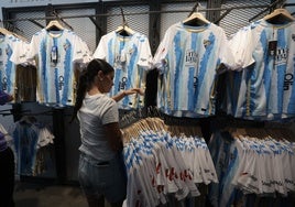 Una empleada de la tienda del Málaga repone una remesa de las nuevas camisetas.