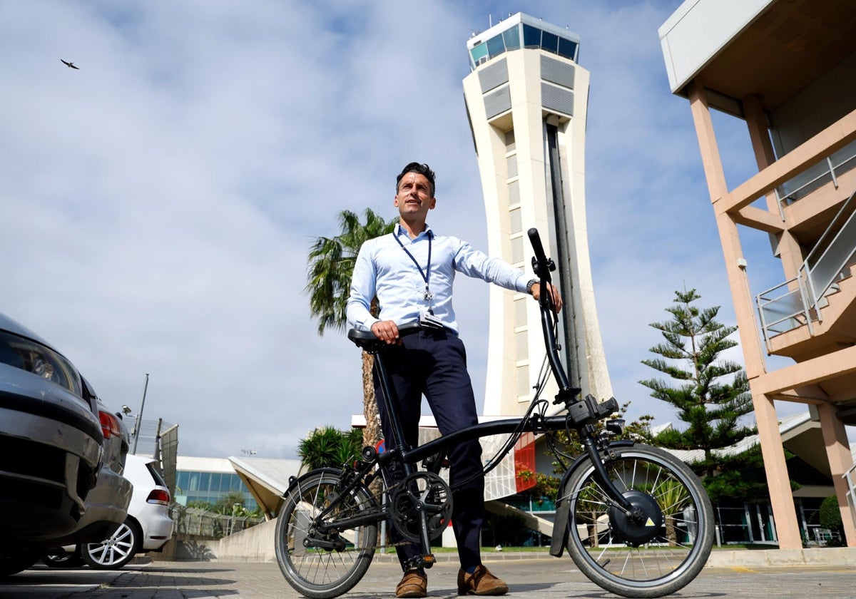 Raúl Delgado, con su bici delante de la torre de control del aeropuerto de Málaga.