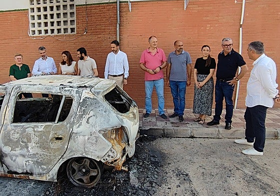 Ediles, alcaldes y dirigentes socialistas, este miércoles en Periana junto al coche incendiado.