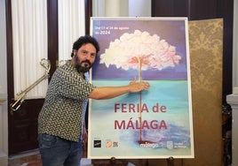 Juan Gómez El Kanka cogiendo de forma imaginaria la biznaga del cartel que este año anuncia la Feria de Málaga, en el salón de los Espejos del Ayuntamiento.