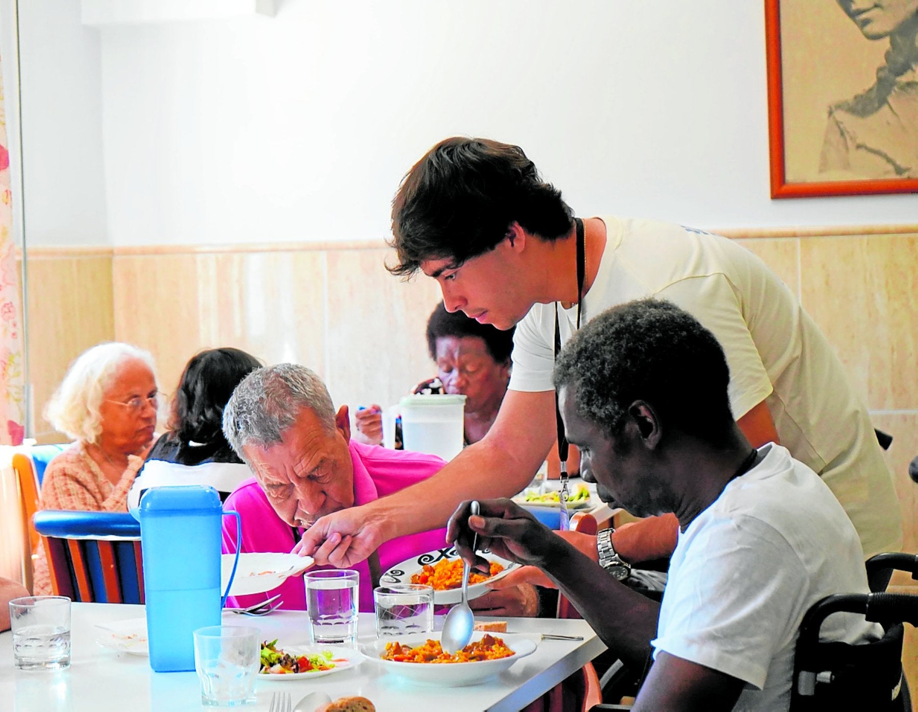 Un joven voluntario atiende el comedor del Cotolengo de Málaga.