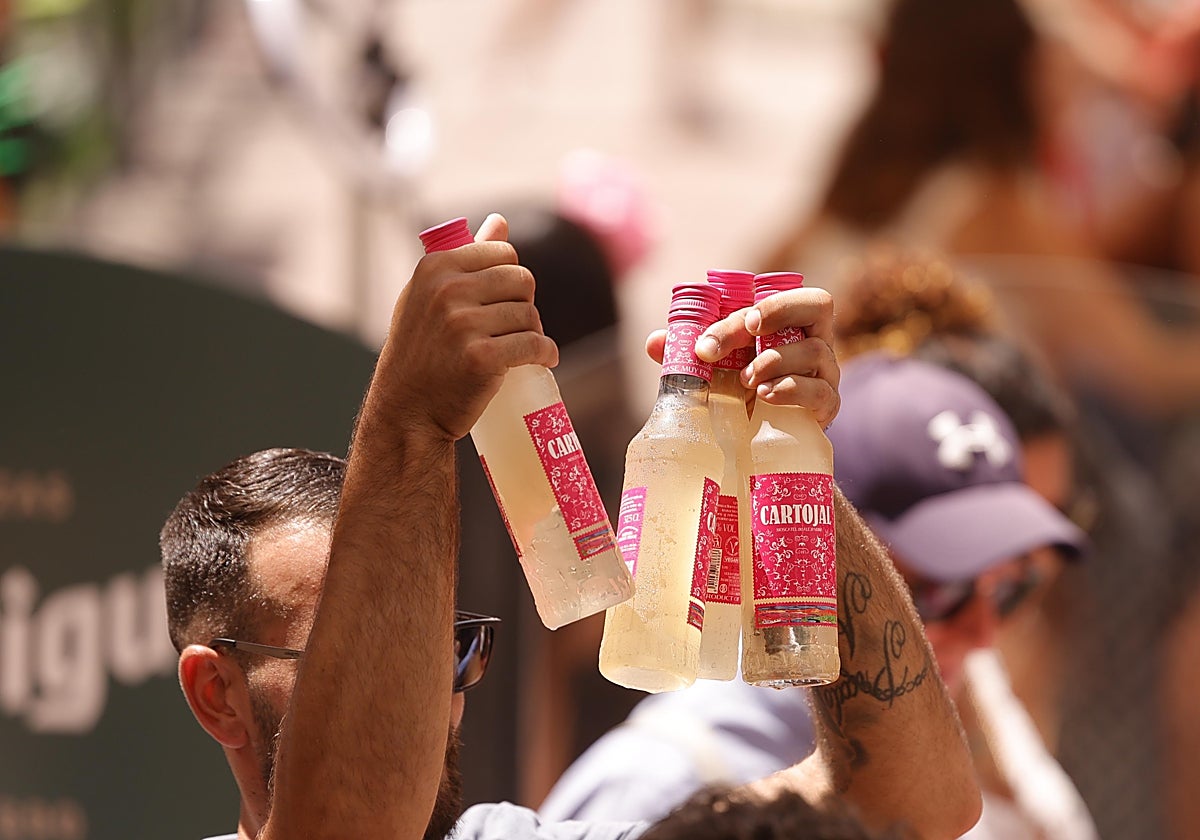 Un hombre sostiene cuatro botellas de Cartojal, una de las bebidas más populares de la feria.