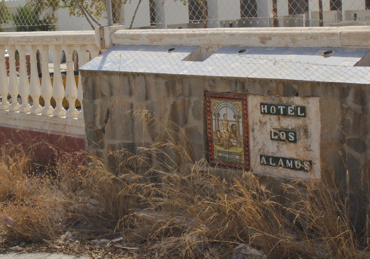 Imagen principal - Antiguo cartel del hotel, material de derribo en el lugar que ocupó Los Álamos y trabajos de construcción del nuevo complejo de apartamentos.