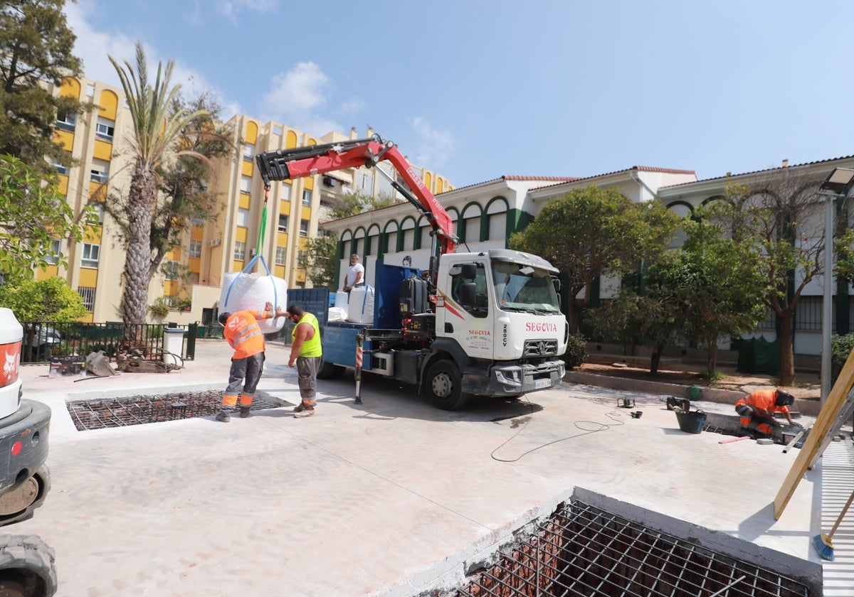 Los operarios están instalando la zona de sombra en el colegio.