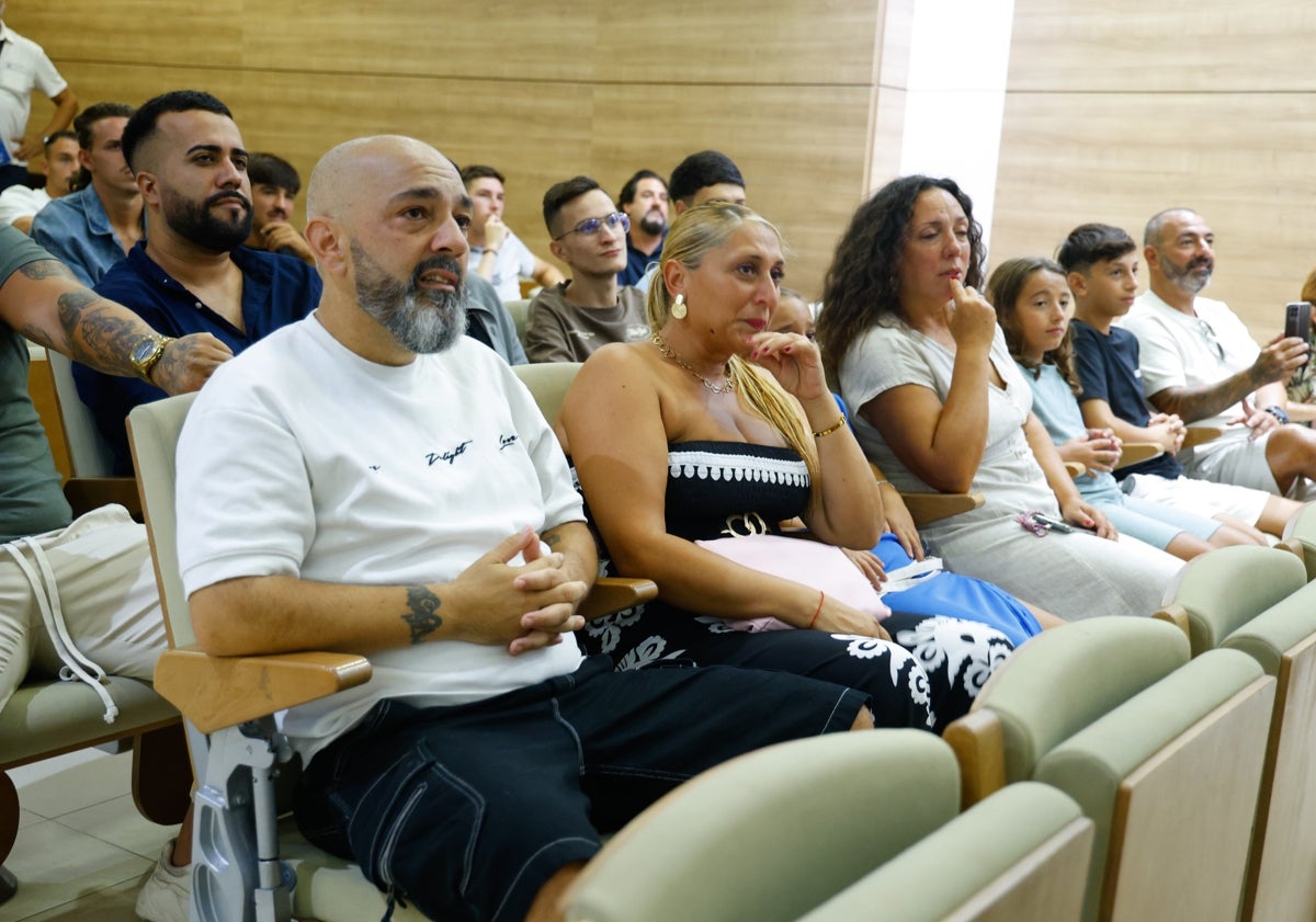 Imagen principal - Familiares del jugador; Muñoz y Pellicer felicitando al propio Izan Merino, y técnicos y compañeros del filial, en el acto de este jueves.