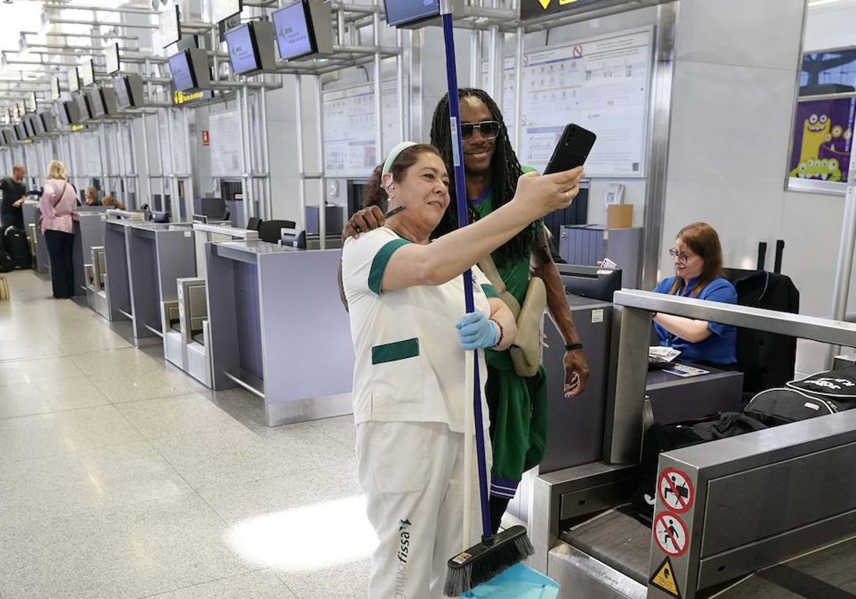 Kendrick Perry se hace una foto con una limpiadora del aeropuerto en una imagen de archivo antes de desplazarse a la final de la Champions League.