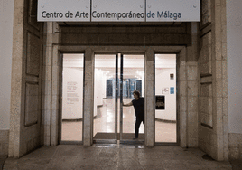 Una trabajadora cierra por última vez las puertas del CAC Málaga.